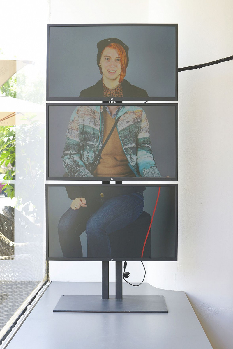 Installation aus drei übereinander montierten Bildschirmen, die ein zusammengesetztes Porträt aus unterschiedlichen Personen ergeben